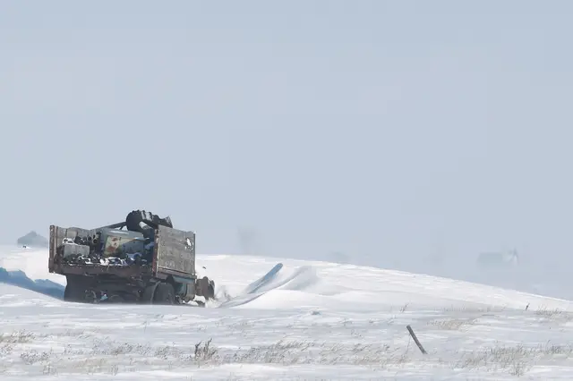 Old truck in a snowy winter field