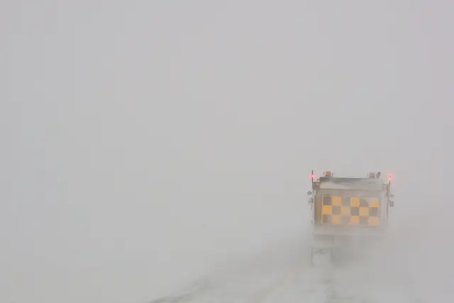 Snowplow in a blizzard on the highway